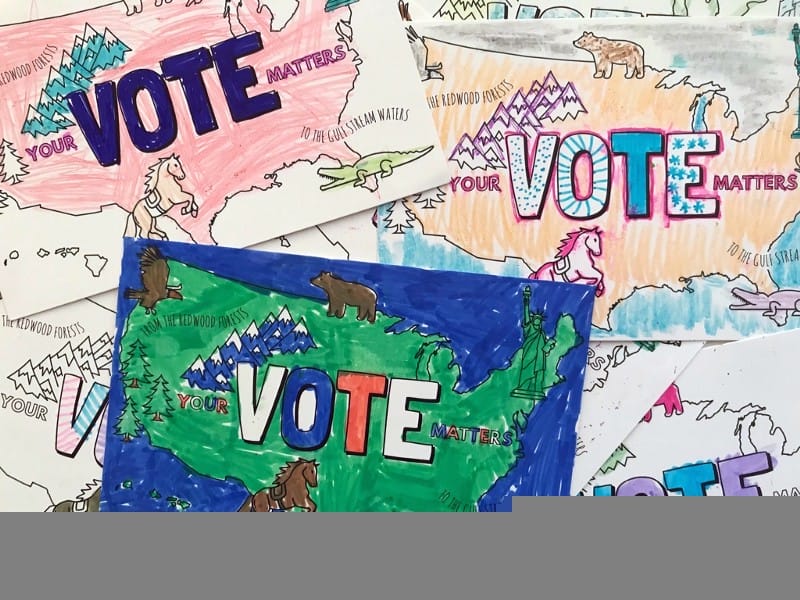 A bunch of postcards with an outline of America and the word VOTE filled in with marker