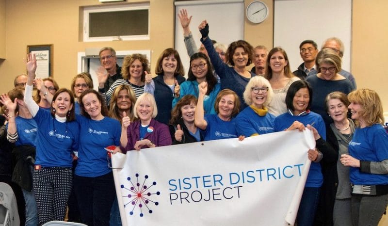 Sister District San Francisco Peninsula volunteers cheering with banner