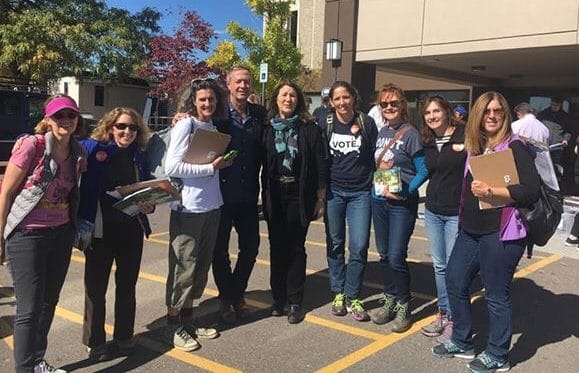 Group of nine Sister District volunteers gather together for a photo a political canvass launch.