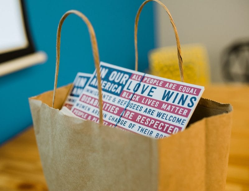 Close-up of postcard saying "in our america love wins" in a paper bag