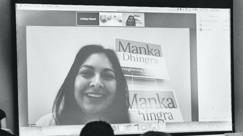 Black and white projector screen displaying a video conference with state legislature candidate Manka Dhingra