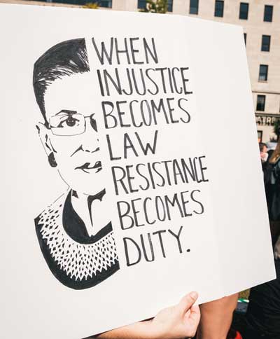 protest sign with Ruth Bader Ginsberg's image with quote "when injustice becomes law resistance becomes duty"