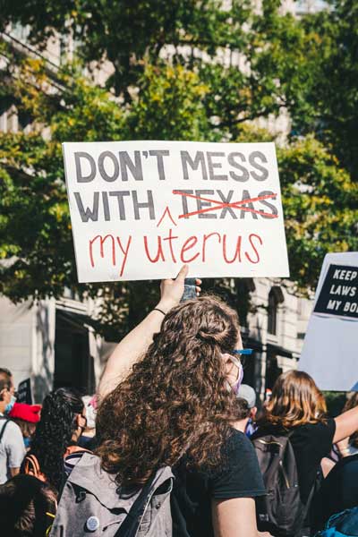Girl at Texas protest for reproductive rights holds a sign that says "don't mess with my uterus"